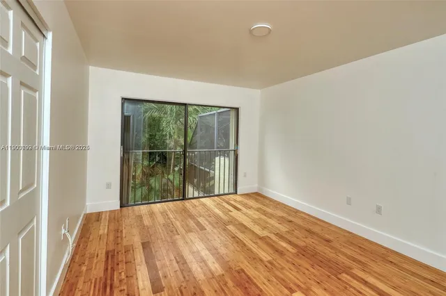 a view of a room with wooden floor and a window