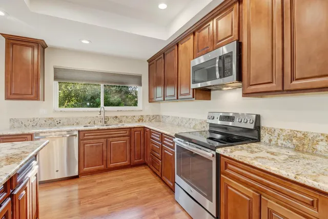 a view of an empty room with wooden floor and closet