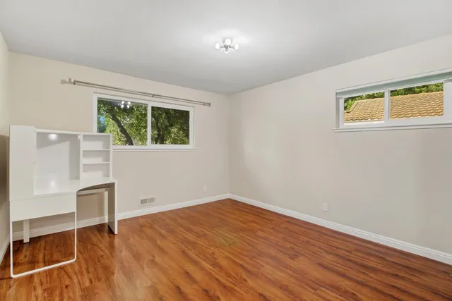 a view of a patio with table and chairs under an umbrella with potted plants