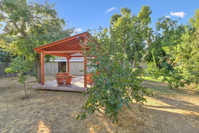 an aerial view of residential houses with outdoor space and trees all around