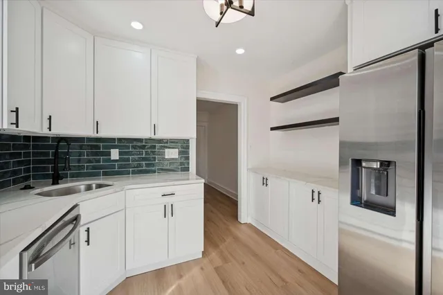 a kitchen with white cabinets and white appliances