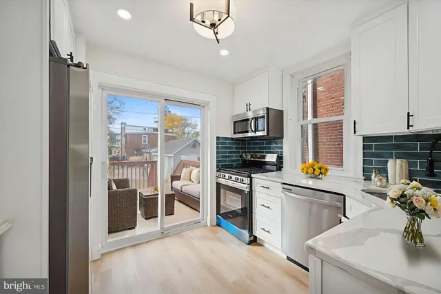 a kitchen with a sink stainless steel appliances and white cabinets