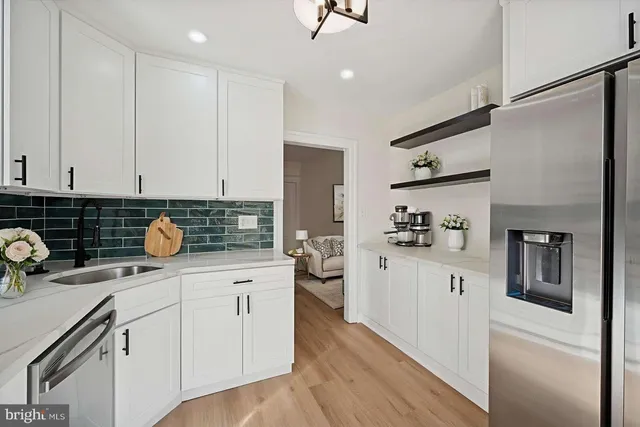 a kitchen with white cabinets and appliances