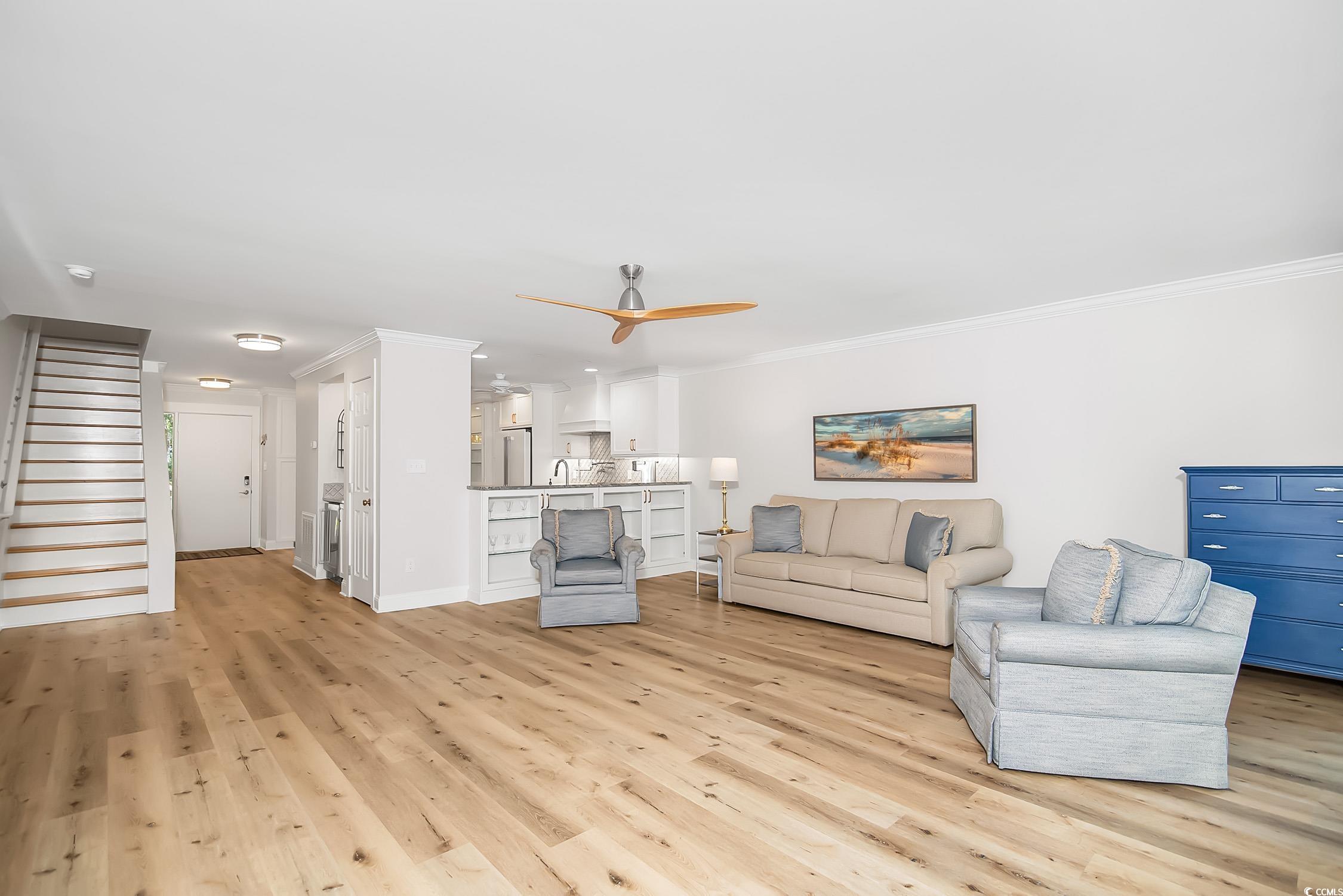 63 Battery White Court, Unit 2C Georgetown, SC 29440 - Photo 15 of 38 Living area featuring stairway, light wood-style floors, ceiling fan, and ornamental molding