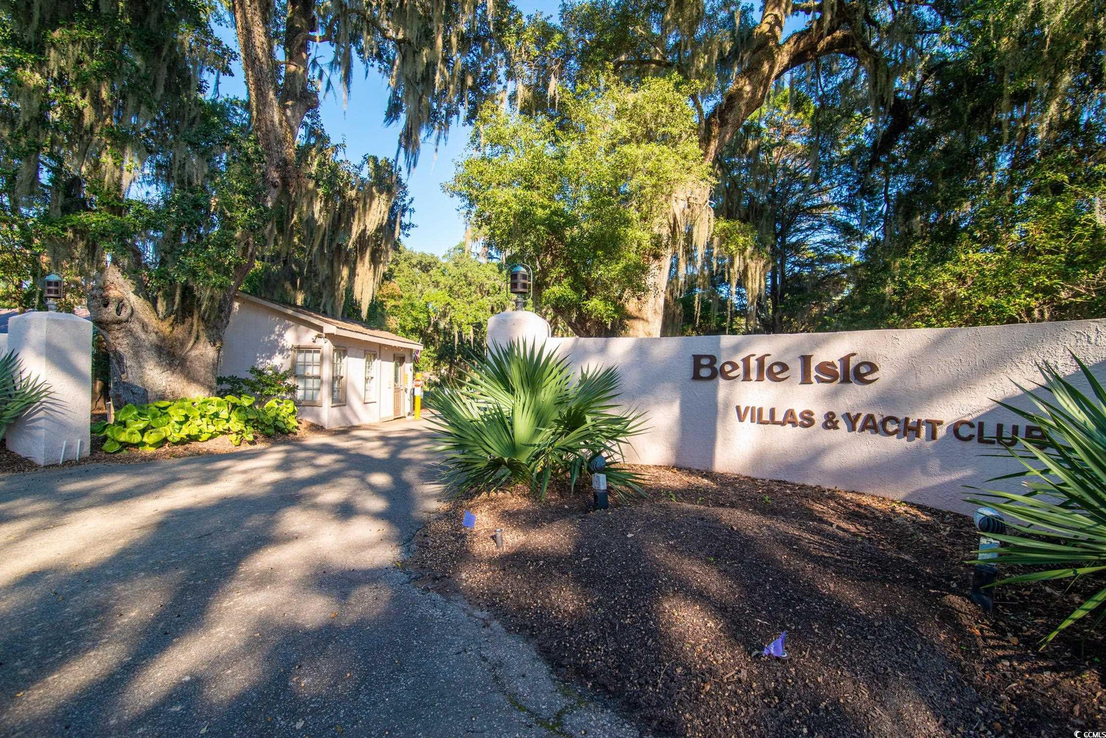 63 Battery White Court, Unit 2C Georgetown, SC 29440 - Photo 2 of 38 Community sign with view of wooded area