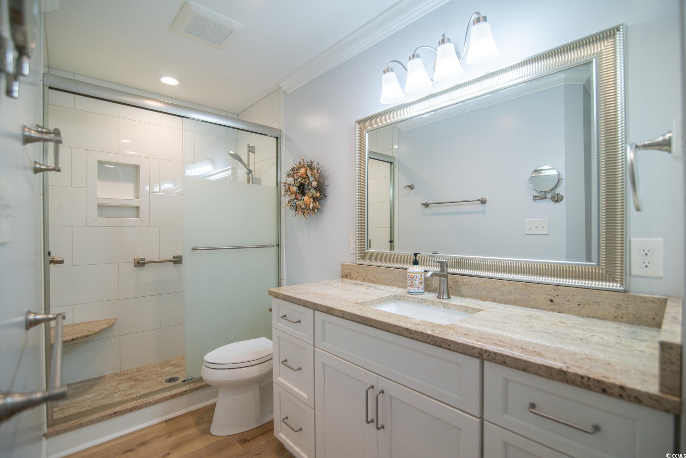 63 Battery White Court, Unit 2C Georgetown, SC 29440 - Photo 21 of 38 Bathroom featuring vanity, a shower stall, light wood-type flooring, ornamental molding, and recessed lighting