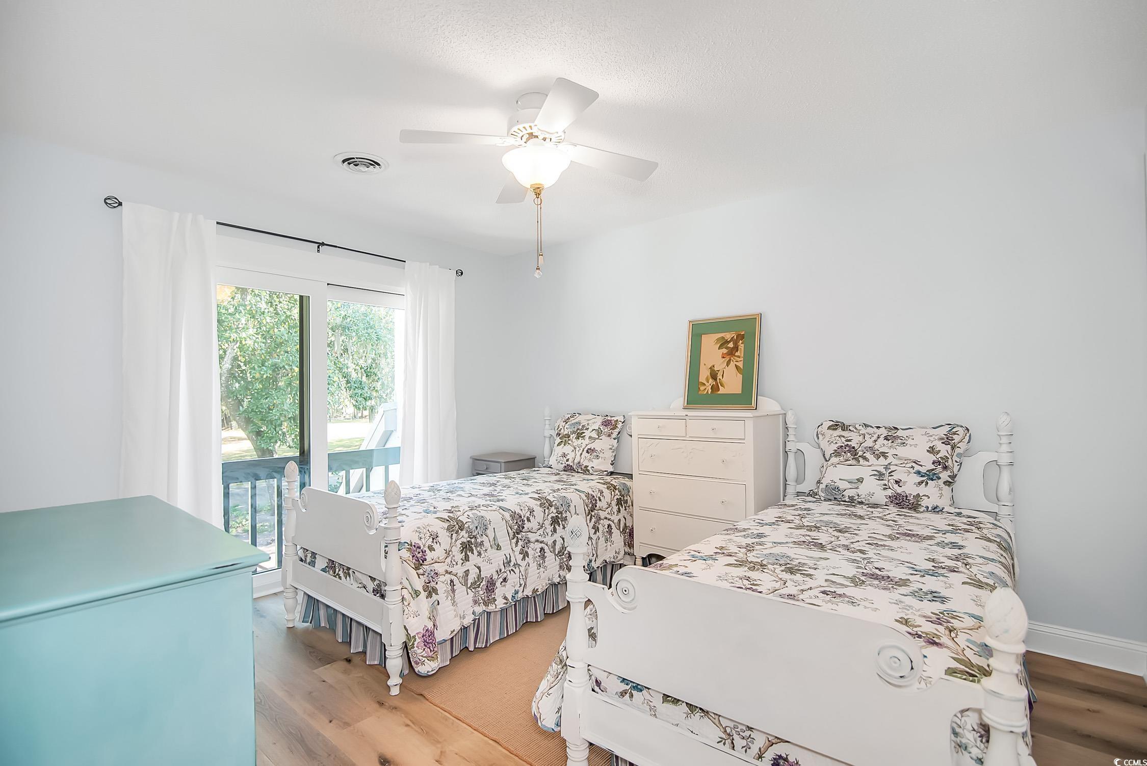 63 Battery White Court, Unit 2C Georgetown, SC 29440 - Photo 22 of 38 Bedroom featuring access to exterior, wood finished floors, and a ceiling fan
