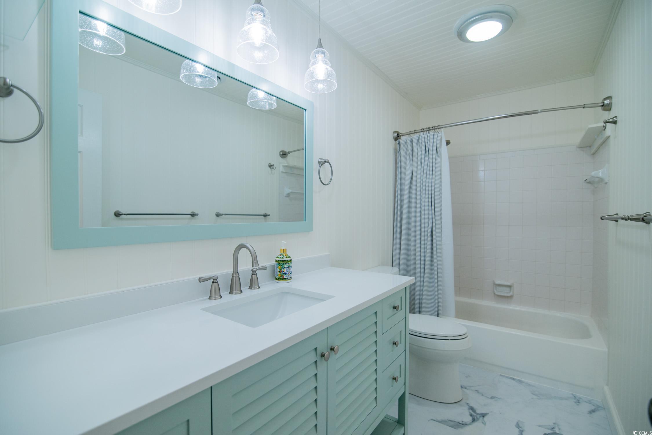 63 Battery White Court, Unit 2C Georgetown, SC 29440 - Photo 23 of 38 Full bathroom featuring vanity, shower / tub combo with curtain, and light marble finish floors