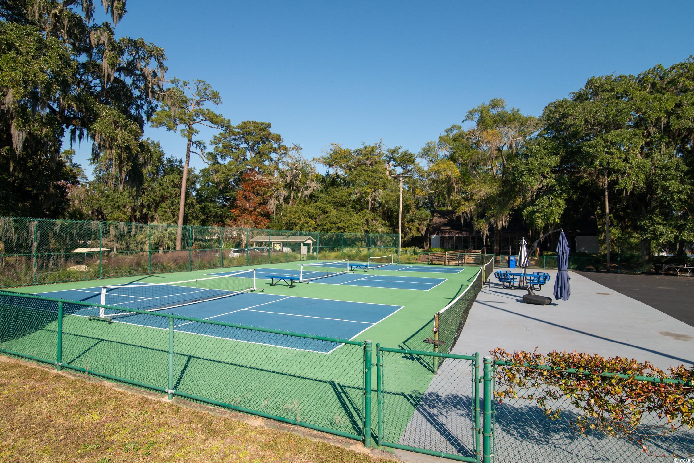 63 Battery White Court, Unit 2C Georgetown, SC 29440 - Photo 31 of 38 View of tennis court featuring a gate, view of scattered trees, and community basketball court