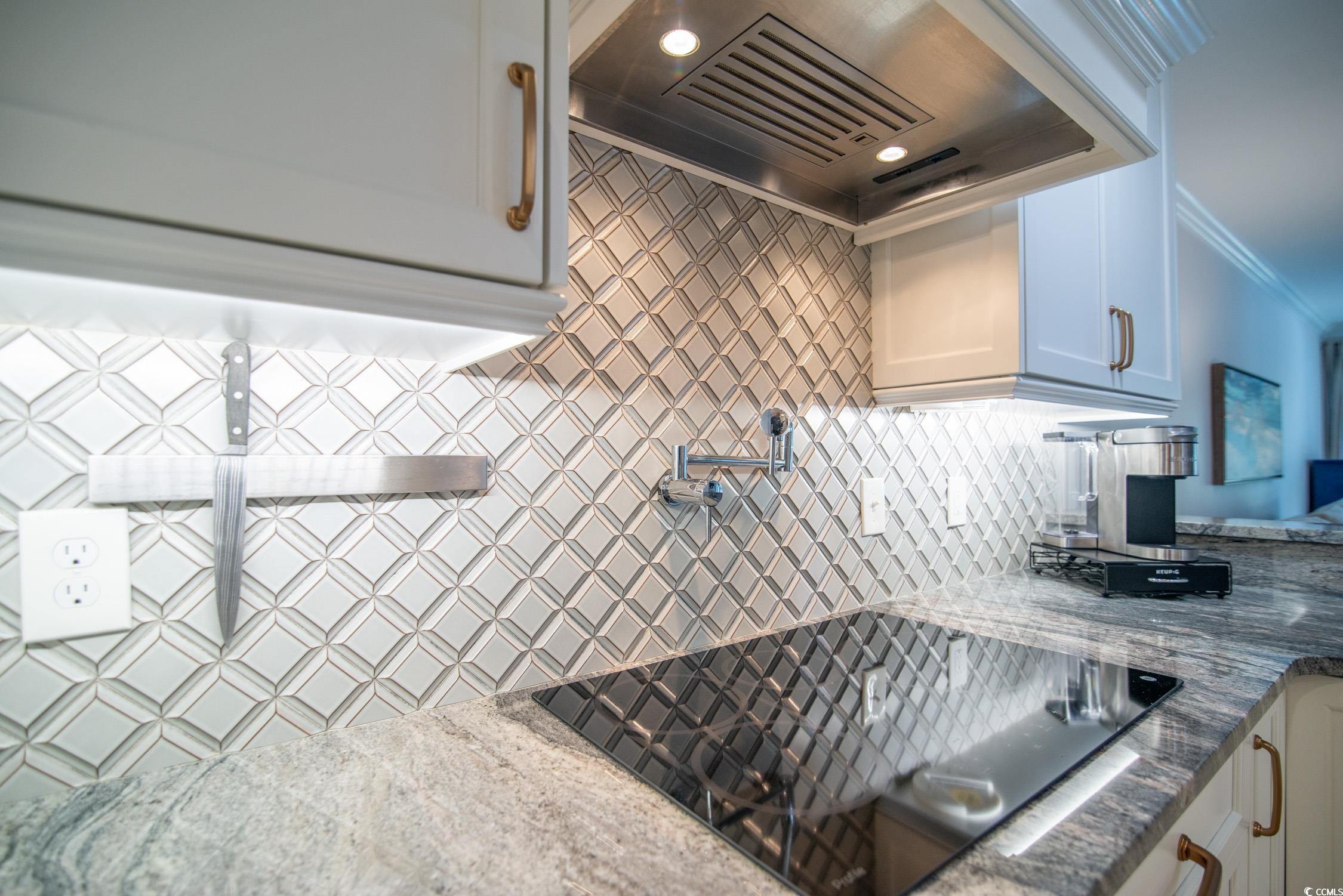 63 Battery White Court, Unit 2C Georgetown, SC 29440 - Photo 5 of 38 Kitchen with custom exhaust hood, black electric stovetop, decorative backsplash, white cabinets, and dark stone countertops