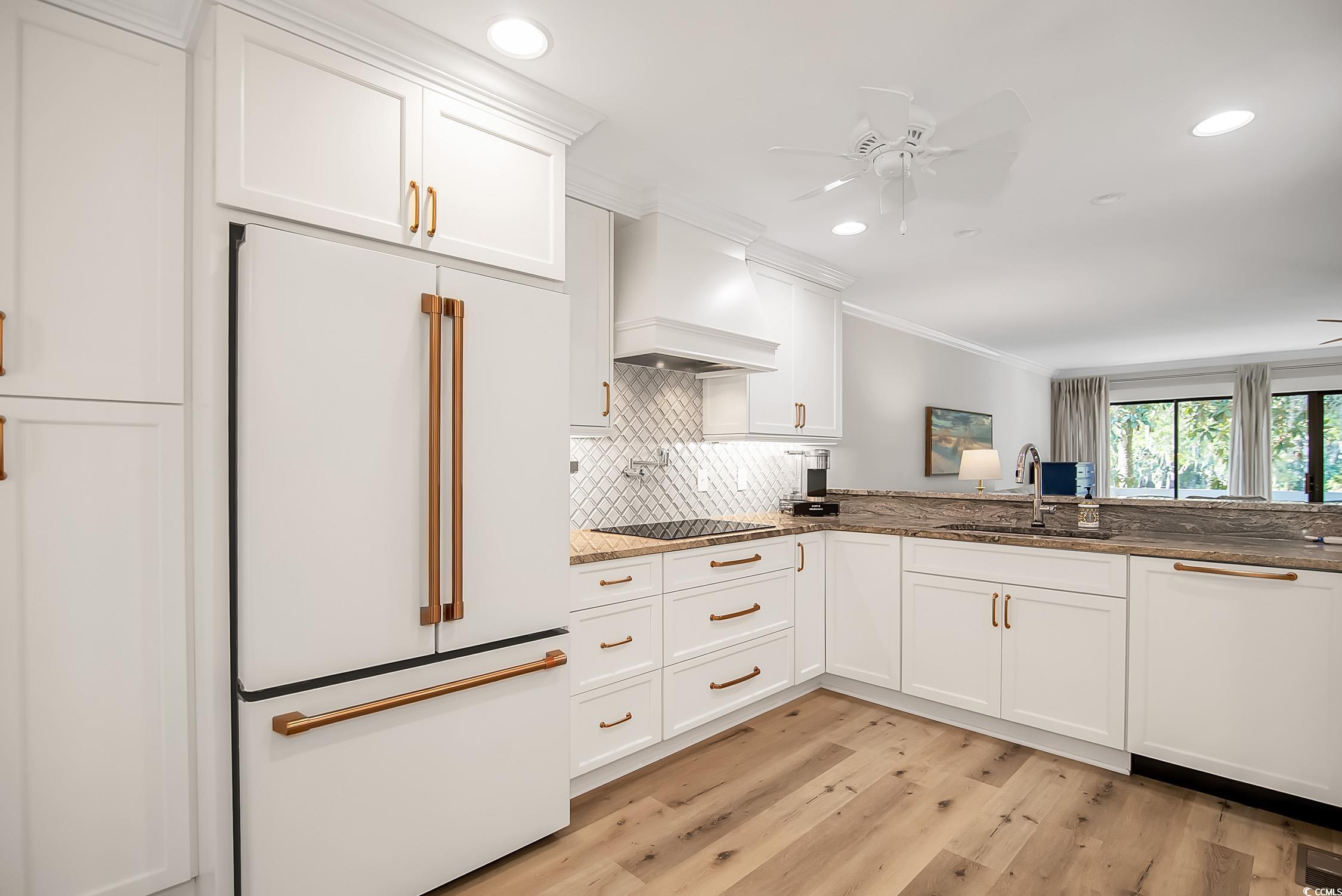63 Battery White Court, Unit 2C Georgetown, SC 29440 - Photo 8 of 38 Kitchen with white appliances, white cabinetry, dark stone counters, a ceiling fan, and ornamental molding