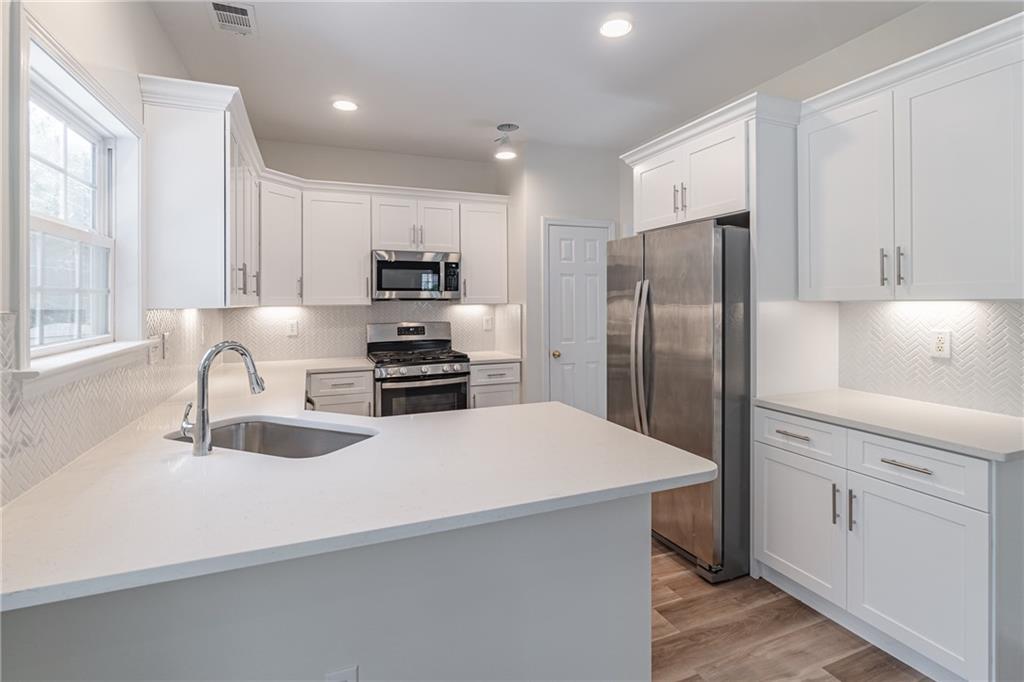 1324 Crescentwood Lane Decatur, GA 30032 - Photo 19 of 58 a kitchen with kitchen island a refrigerator sink and white cabinets