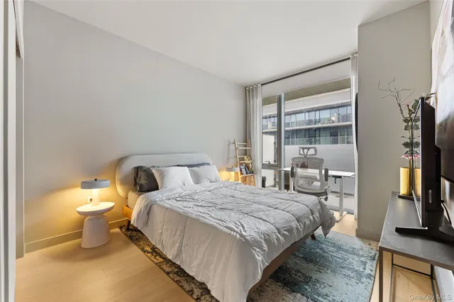 a bedroom with a bed and a flat tv screen on a dresser