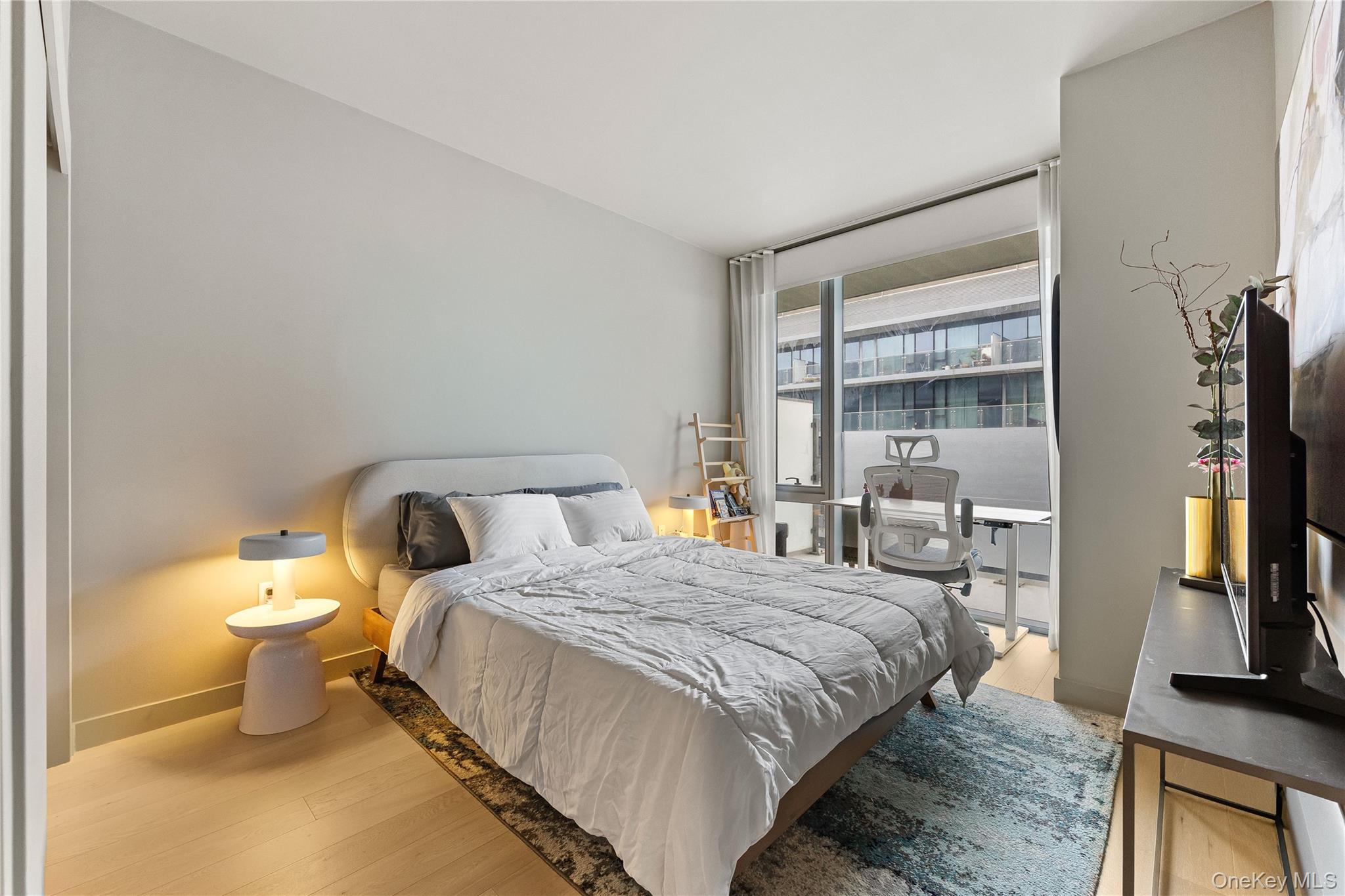 131-01 40 Road, Unit PH3F Queens, NY 11354 - Photo 13 of 30 a bedroom with a bed and a flat tv screen on a dresser