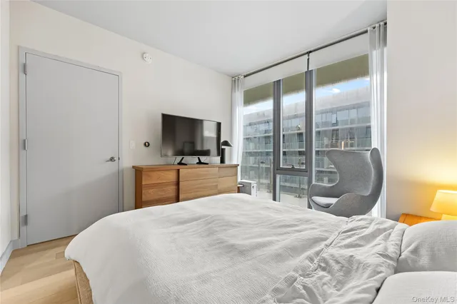 a bedroom with a large bed and a flat tv screen on dresser