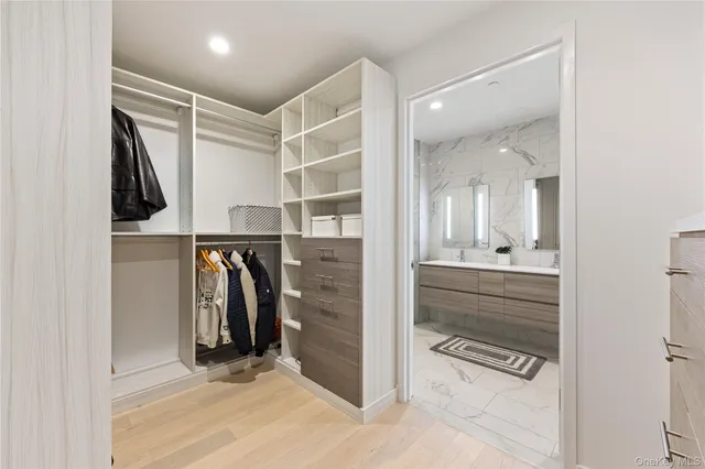 a view of walk in closet with clothes and shoes