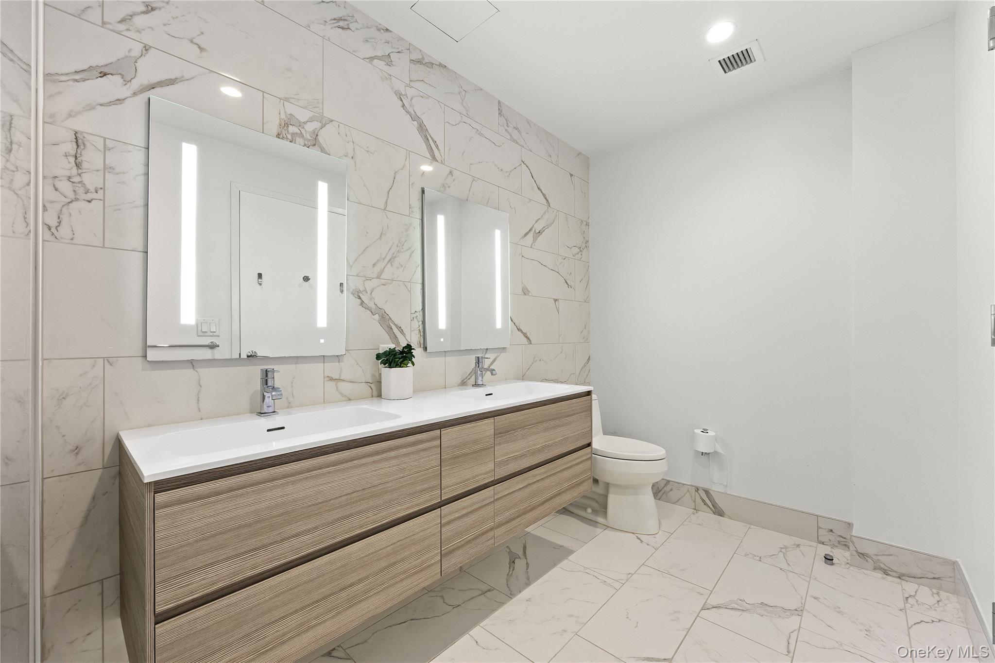 131-01 40 Road, Unit PH3F Queens, NY 11354 - Photo 24 of 30 a bathroom with a double vanity sink toilet and a mirror