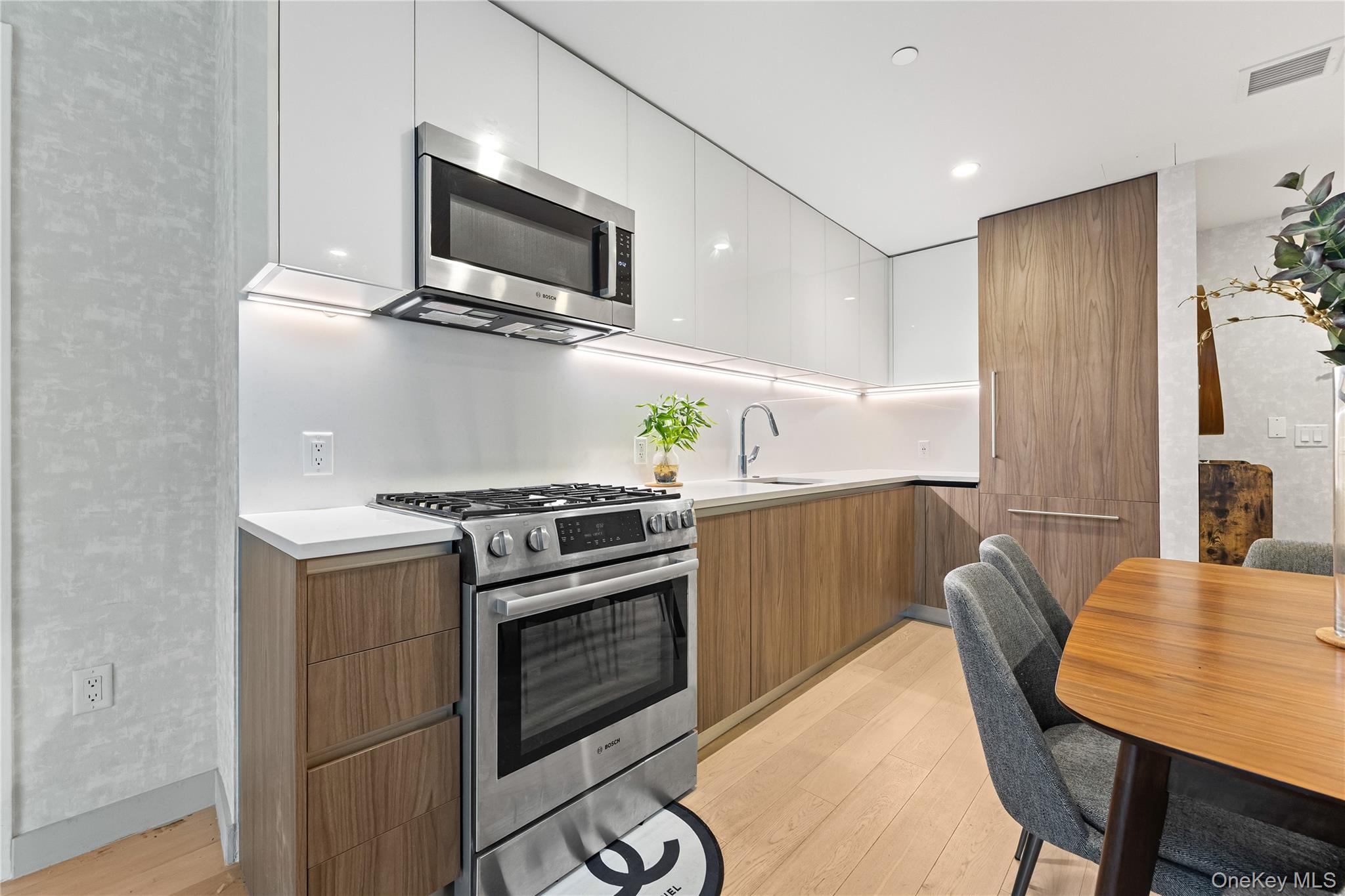 131-01 40 Road, Unit PH3F Queens, NY 11354 - Photo 26 of 30 a kitchen with stainless steel appliances a stove a microwave a sink and white cabinets