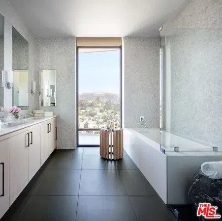 a bathroom with a bathtub sink and mirror