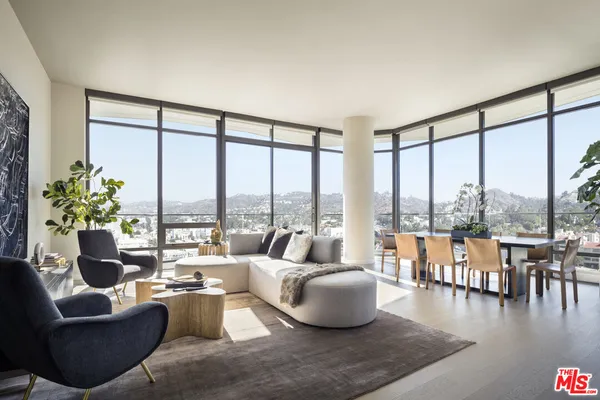 a living room with furniture and floor to ceiling windows