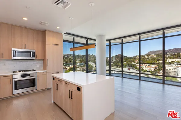 a large kitchen with stainless steel appliances granite countertop a large stove and a wooden floor