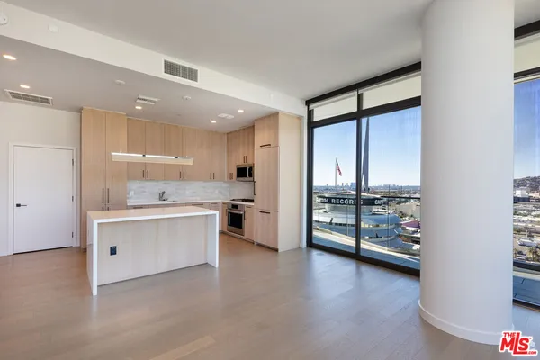 a kitchen with white cabinets and window