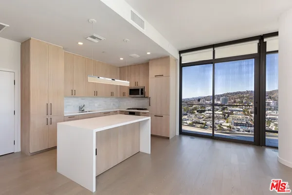 a kitchen with stainless steel appliances a stove top oven a refrigerator and a table