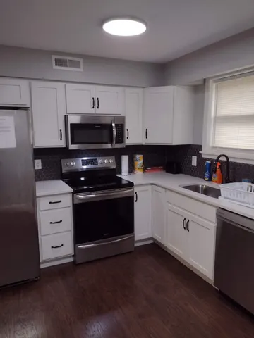 a kitchen with cabinets appliances and a window
