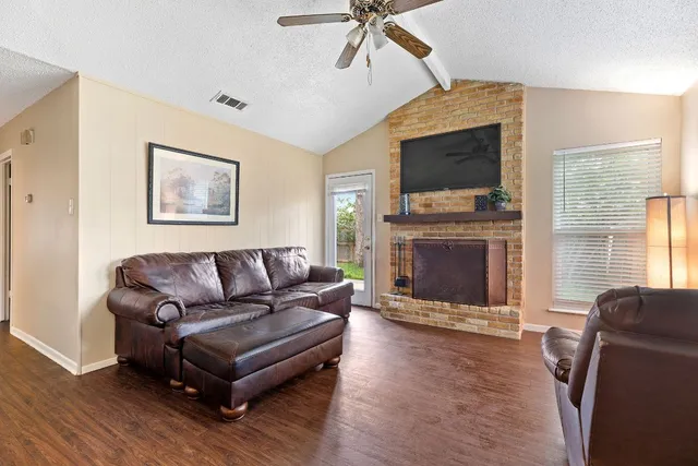 a living room with furniture a flat screen tv and a fireplace