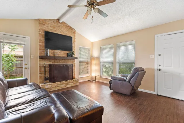 a living room with furniture a flat screen tv and a fireplace