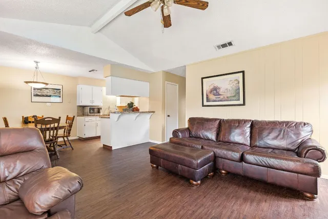 a living room with furniture and a wooden floor
