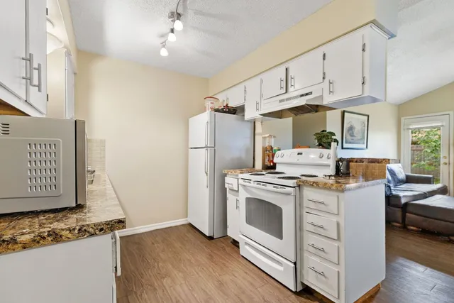 a kitchen with stainless steel appliances granite countertop a stove and a refrigerator