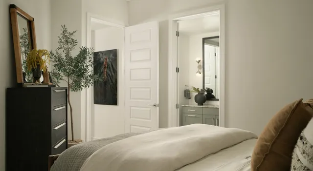 a bedroom with a bed and a potted plant