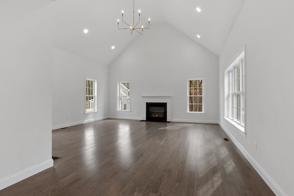 7 Robinson Road Pepperell, MA 01463 - Photo 12 of 30 an empty room with wooden floor and fireplace