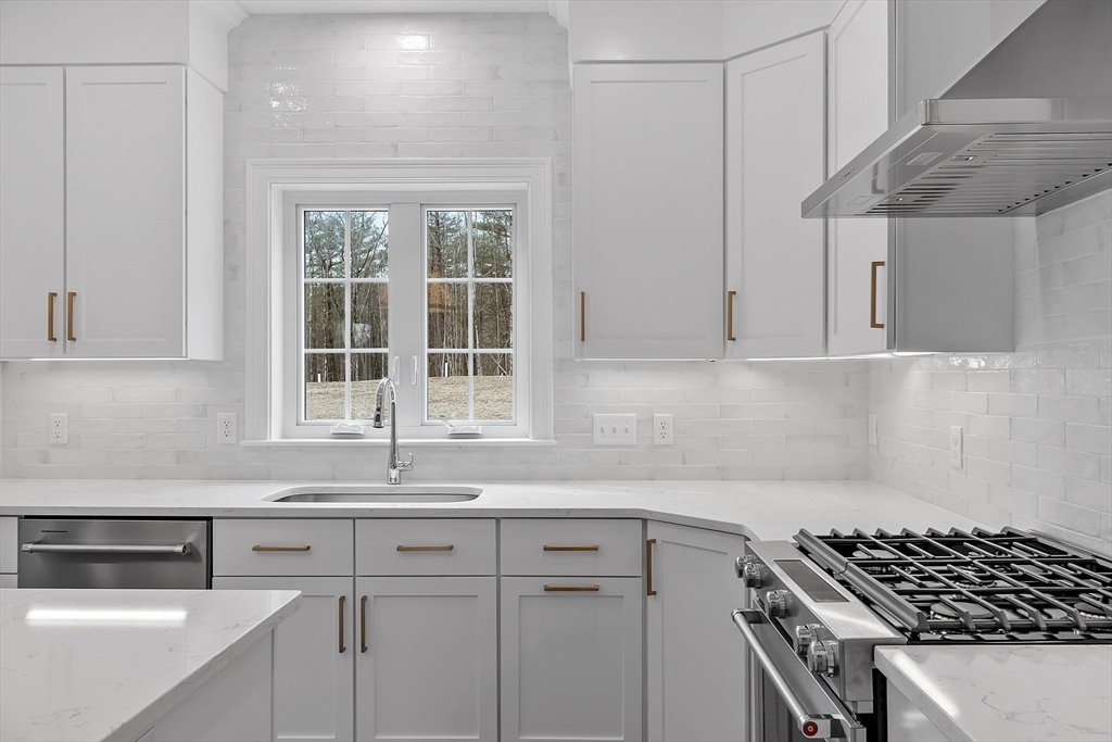 7 Robinson Road Pepperell, MA 01463 - Photo 17 of 30 a kitchen with granite countertop a sink a stove and cabinets