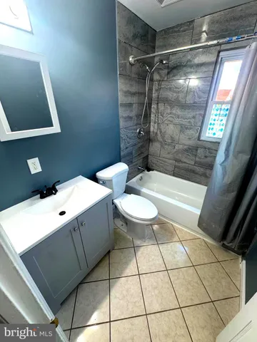 a bathroom with a white toilet a sink and bathtub