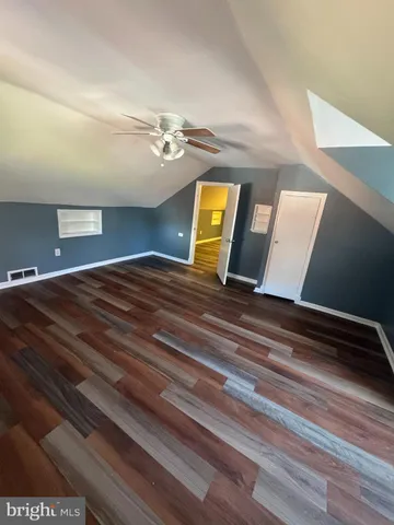 a view of a room with wooden floor and a ceiling fan