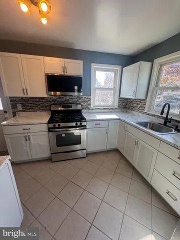 a kitchen with a sink stove and cabinets