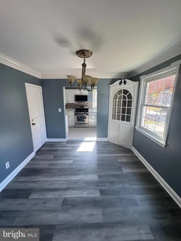 a view of empty room with wooden floor and window