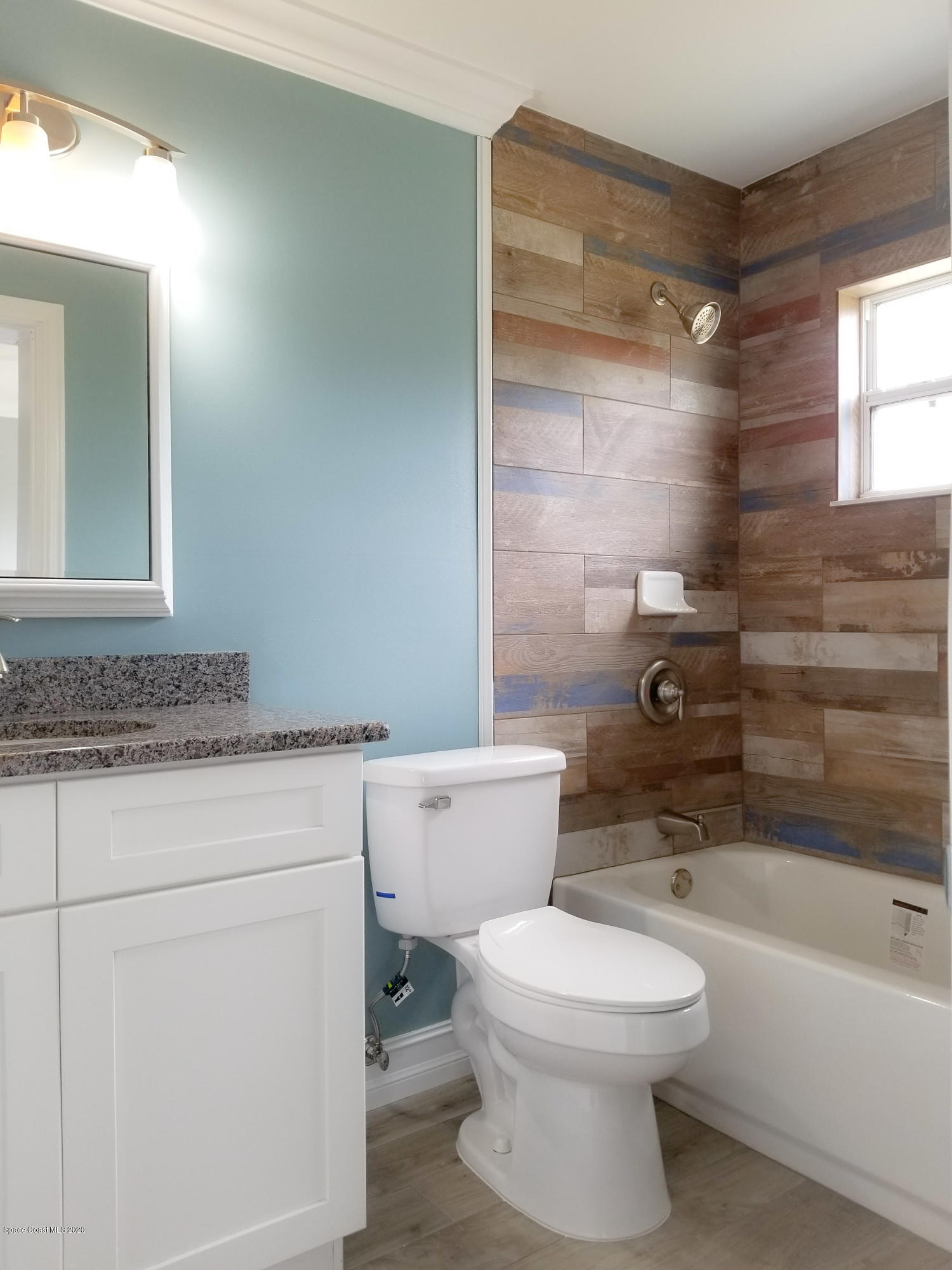 1986 Sarno Road Melbourne, FL 32935 - Photo 14 of 35 a bathroom with a granite countertop toilet a sink and bathtub
