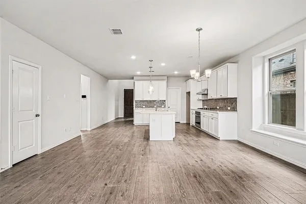 a large kitchen with white cabinets stainless steel appliances
