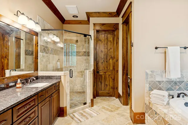a bathroom with a granite countertop sink a mirror and shower