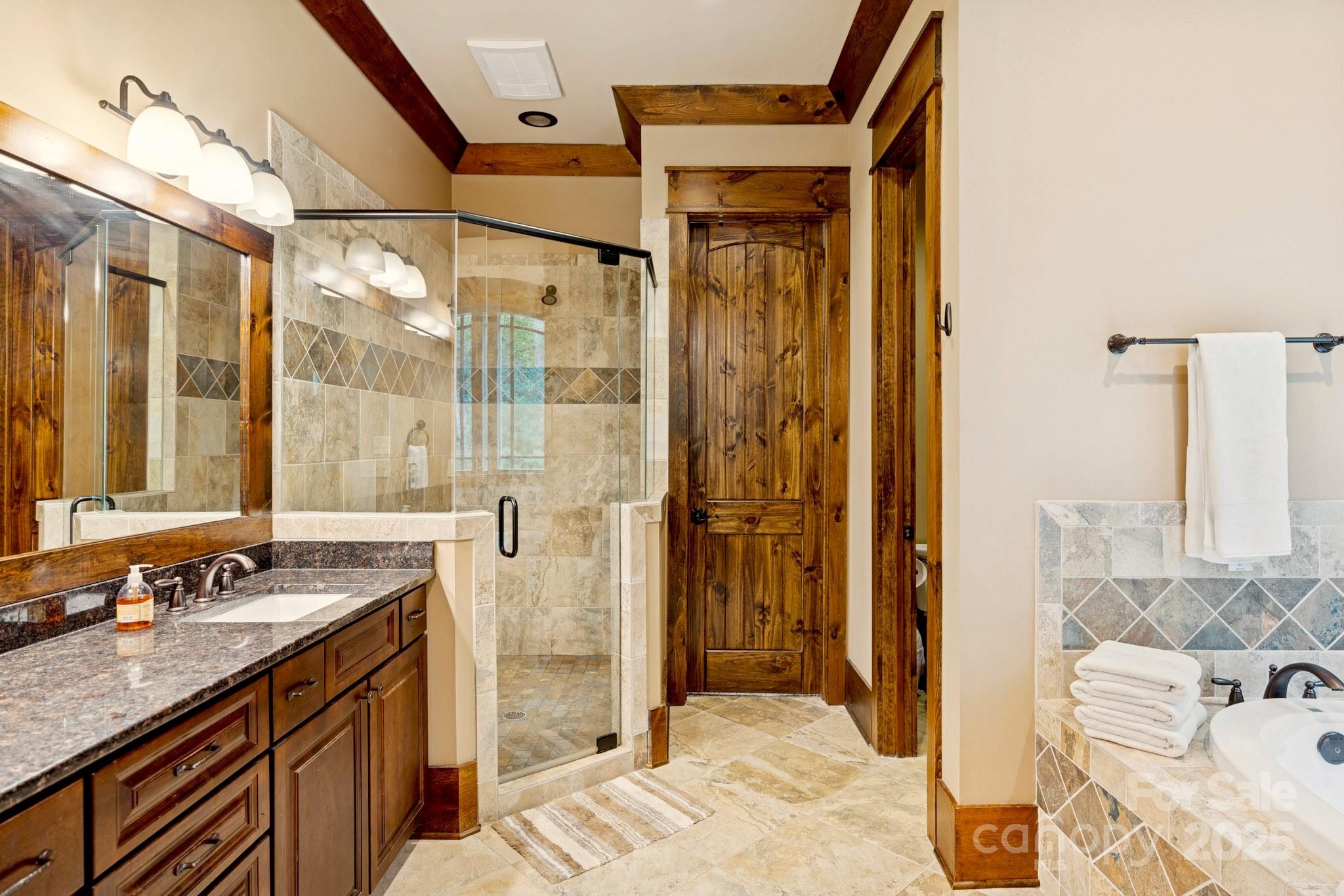 23 Dividing Ridge Trail Arden, NC 28704 - Photo 13 of 34 a bathroom with a granite countertop sink a mirror and shower