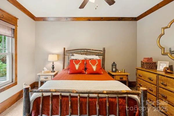 a bedroom with a bed a dresser and a window