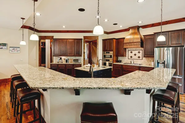 a kitchen with kitchen island granite countertop a table and chairs in it