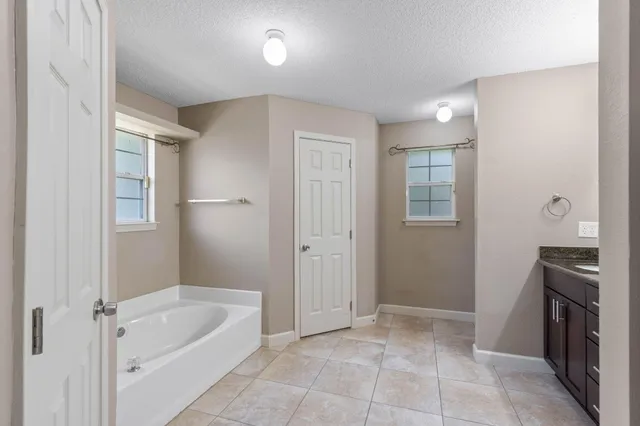 a bathroom with a tub sink and mirror