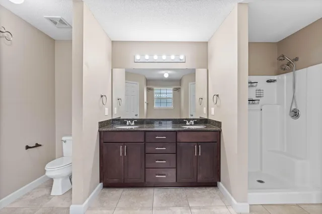 a bathroom with a granite countertop sink a toilet and a mirror