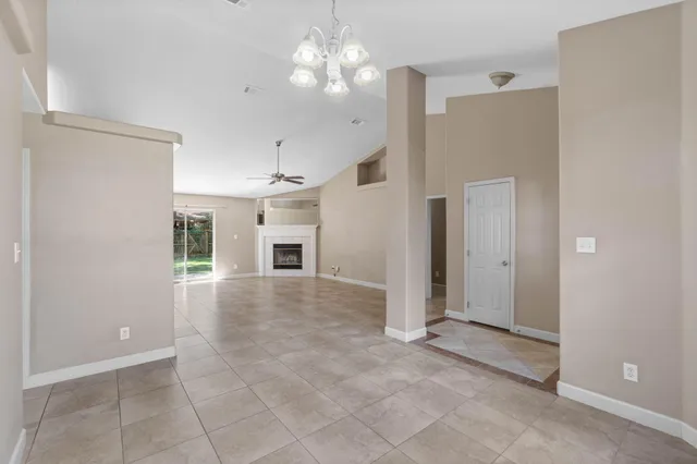 a view of a livingroom with a ceiling fan window and a kitchen view