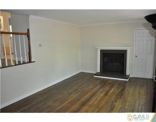 16 Donald Road East Brunswick, NJ 08816 - Photo 5 of 25 a view of an empty room with wooden floor and a fireplace