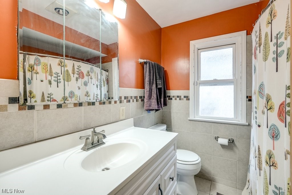 4828 South Sedgewick Road Cleveland, OH 44124 - Photo 13 of 19 Bathroom with toilet, tile floors, tile walls, and vanity